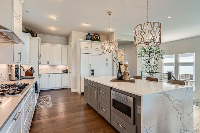 10119 Bellwether Ln, Lone Tree, CO 80124 - kitchen with tasteful backsplash, a sink, a chandelier, built in appliances, and white cabinetry