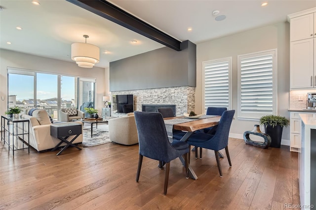 10119 Bellwether Ln, Lone Tree, CO 80124 - dining space featuring beam ceiling, a stone fireplace, recessed lighting, baseboards, and hardwood / wood-style flooring