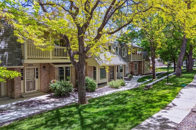 7589 S Cove Cir, Centennial, CO 80122 - view of front of property featuring brick siding, a balcony, and a front lawn