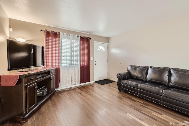 living room featuring wood-type flooring and baseboards