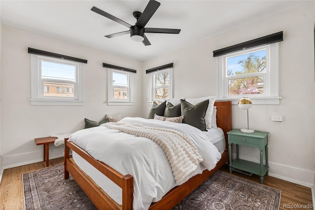 bedroom featuring baseboards, ceiling fan, and wood finished floors