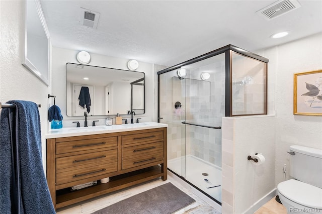 full bathroom featuring a shower stall, visible vents, a sink, and toilet