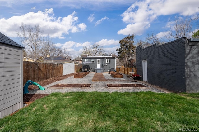 view of yard featuring a patio, an outbuilding, and a fenced backyard