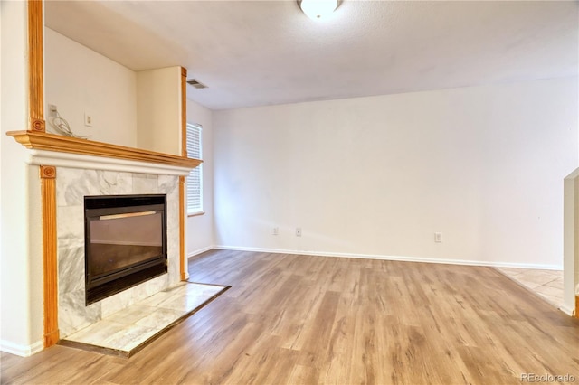 unfurnished living room featuring a fireplace and light hardwood / wood-style floors