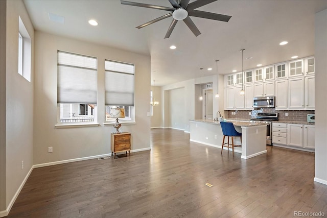 3336 Goodyear St, Castle Rock, CO 80109 - kitchen featuring stainless steel appliances, white cabinetry, decorative backsplash, ceiling fan, and an island with sink