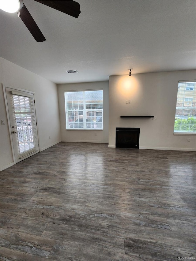 9220 Wilde Ln Unit 102, Parker, CO 80134 - unfurnished living room featuring ceiling fan, a fireplace, dark wood-type flooring, and baseboards