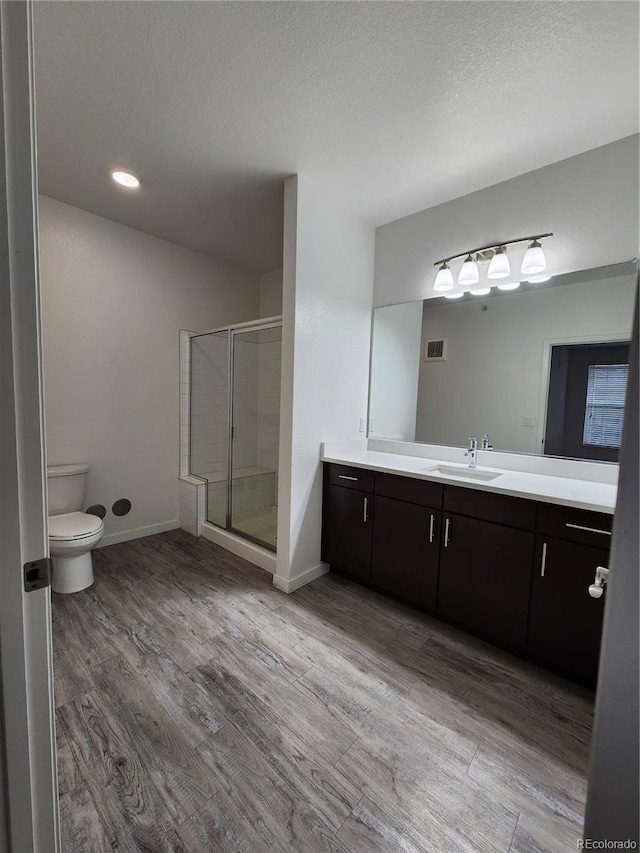 9220 Wilde Ln Unit 102, Parker, CO 80134 - bathroom with vanity, a shower stall, toilet, wood finished floors, and baseboards