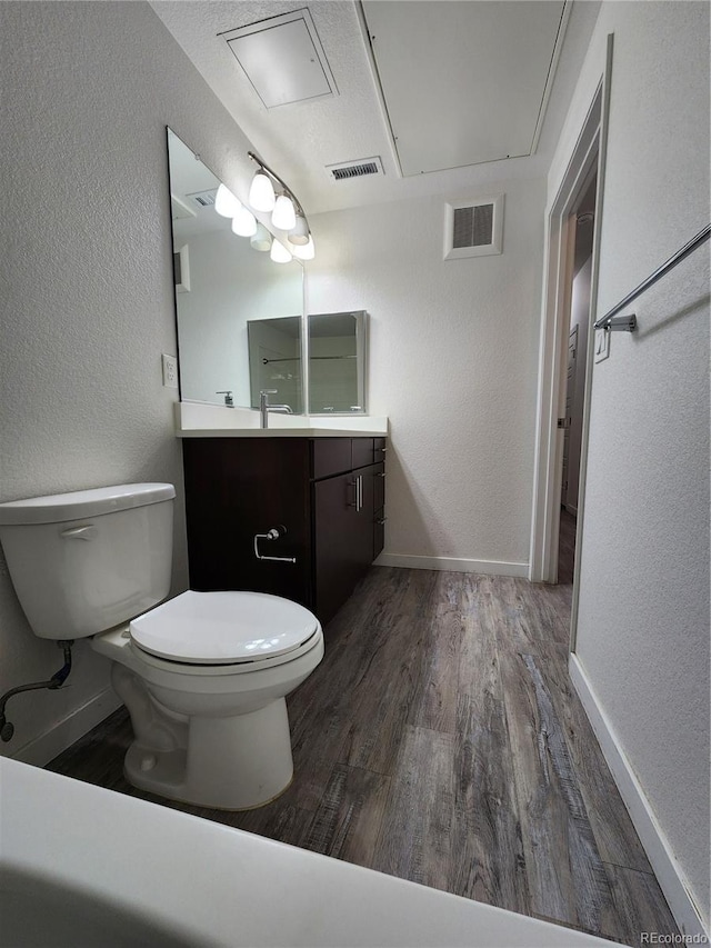 9220 Wilde Ln Unit 102, Parker, CO 80134 - bathroom featuring a textured wall, toilet, wood finished floors, vanity, and baseboards