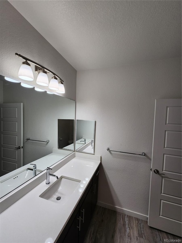 9220 Wilde Ln Unit 102, Parker, CO 80134 - bathroom with wood finished floors, a textured ceiling, vanity, baseboards, and a textured wall
