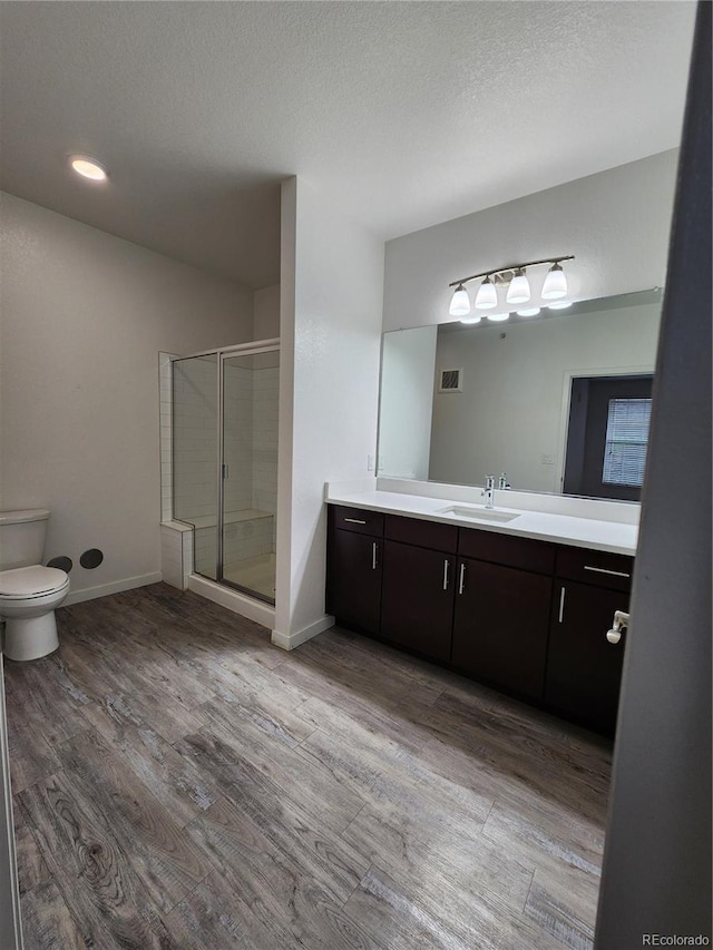 9220 Wilde Ln Unit 102, Parker, CO 80134 - bathroom with vanity, a shower stall, toilet, wood finished floors, and baseboards