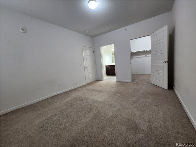 9220 Wilde Ln Unit 102, Parker, CO 80134 - unfurnished bedroom featuring carpet floors, baseboards, a walk in closet, and a closet