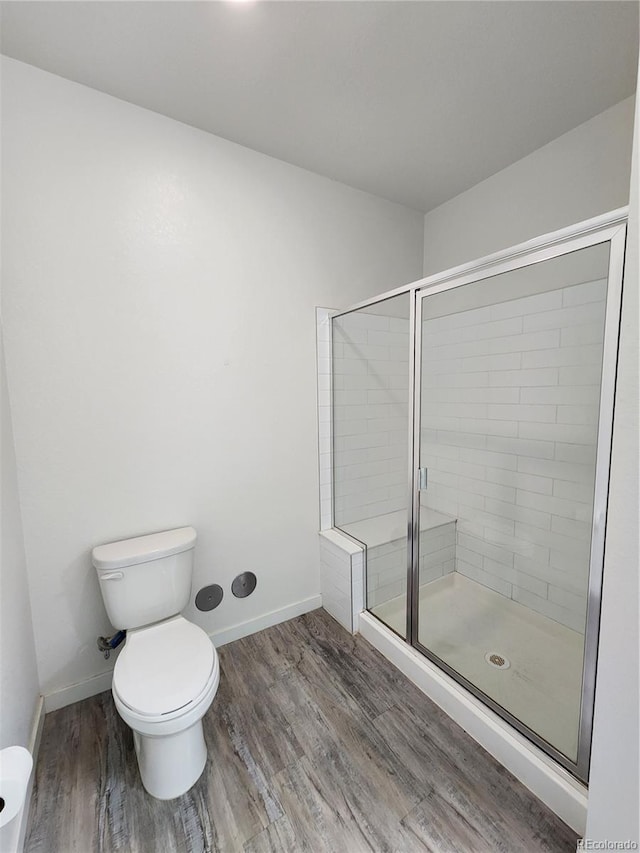 9220 Wilde Ln Unit 102, Parker, CO 80134 - bathroom featuring toilet, a shower stall, wood finished floors, and baseboards
