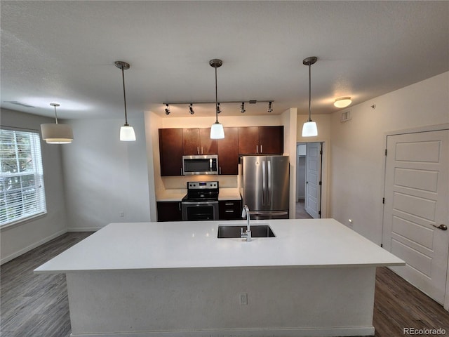 9220 Wilde Ln Unit 102, Parker, CO 80134 - kitchen featuring stainless steel appliances, a sink, light countertops, dark wood-style flooring, and track lighting