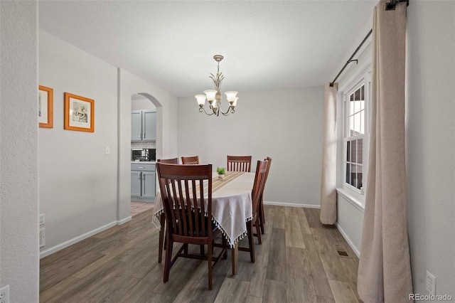 dining room featuring dark hardwood / wood-style flooring and a chandelier