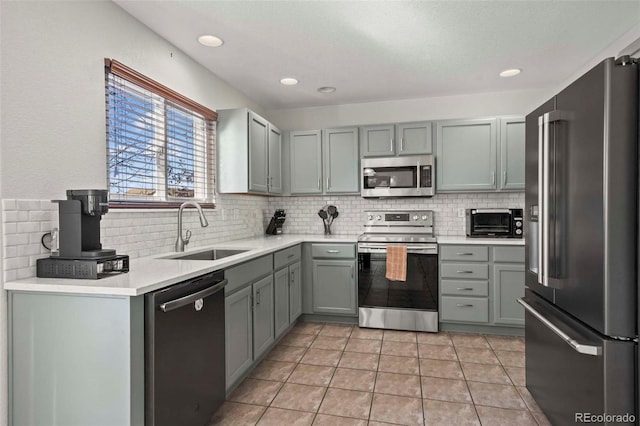 kitchen featuring tasteful backsplash, sink, light tile patterned floors, and appliances with stainless steel finishes