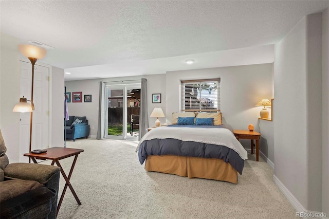 bedroom featuring a textured ceiling, carpet floors, and access to outside