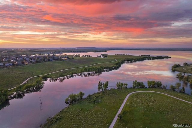 aerial view at dusk featuring a water view