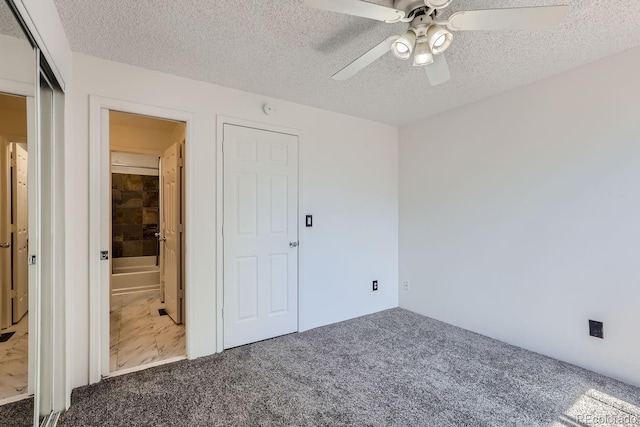 unfurnished bedroom featuring a ceiling fan, carpet floors, and a textured ceiling