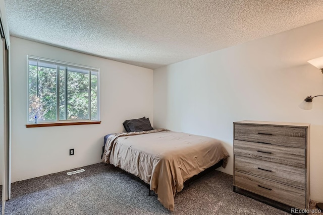 carpeted bedroom featuring visible vents and a textured ceiling