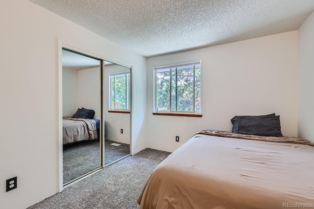 bedroom featuring a closet, a textured ceiling, and carpet floors