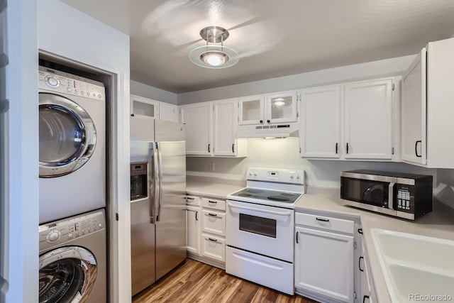 kitchen featuring under cabinet range hood, white cabinets, appliances with stainless steel finishes, and stacked washer and dryer