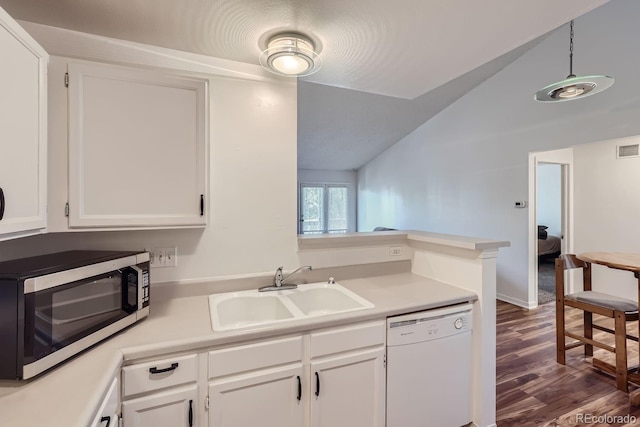 kitchen featuring stainless steel microwave, vaulted ceiling, white dishwasher, white cabinets, and a sink