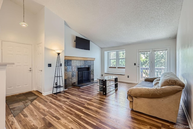 living area featuring wood finished floors, a fireplace, baseboards, and a textured ceiling