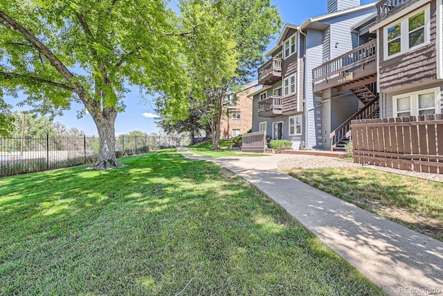 surrounding community featuring stairway, a yard, and fence