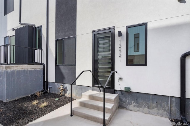 doorway to property featuring stucco siding