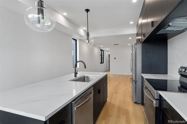 kitchen featuring under cabinet range hood, a sink, appliances with stainless steel finishes, light wood-type flooring, and modern cabinets