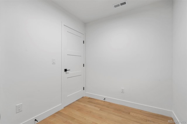 spare room with light wood-style flooring, visible vents, and baseboards