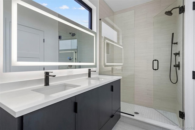 full bathroom featuring double vanity, a stall shower, and a sink