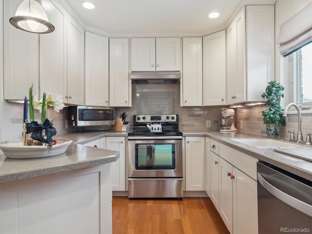 kitchen with sink, backsplash, white cabinetry, and appliances with stainless steel finishes