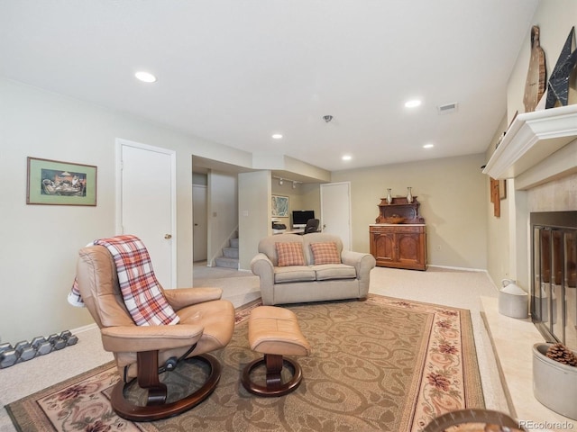 carpeted living room with a tiled fireplace