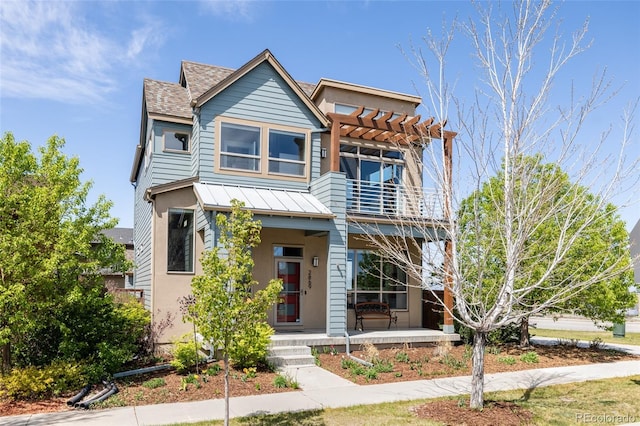 view of front of property with a pergola, a balcony, a standing seam roof, metal roof, and a porch