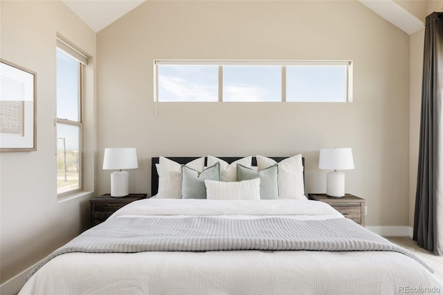 bedroom with carpet floors, baseboards, and vaulted ceiling