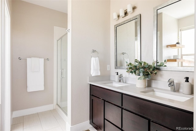 bathroom with a sink, baseboards, and a shower stall