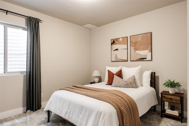 carpeted bedroom featuring baseboards and multiple windows