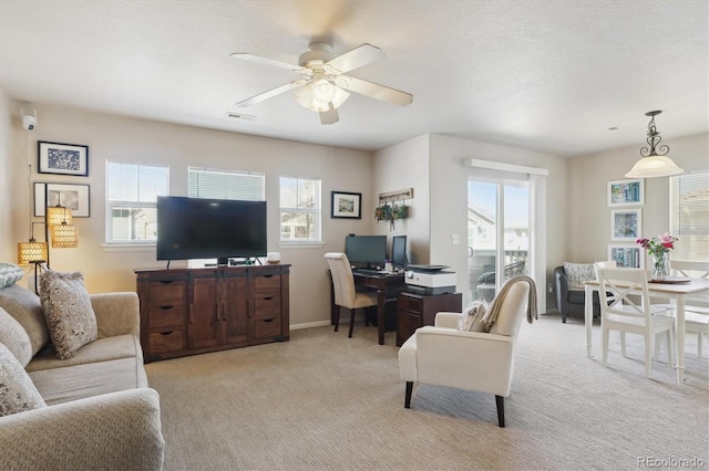 living room with visible vents, light colored carpet, a ceiling fan, a textured ceiling, and baseboards