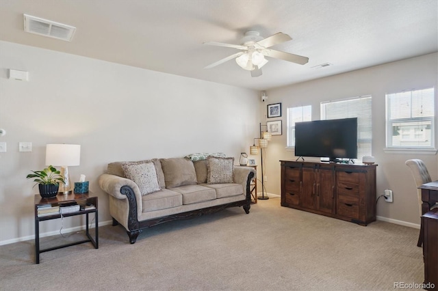 living area featuring baseboards, carpet floors, visible vents, and a ceiling fan