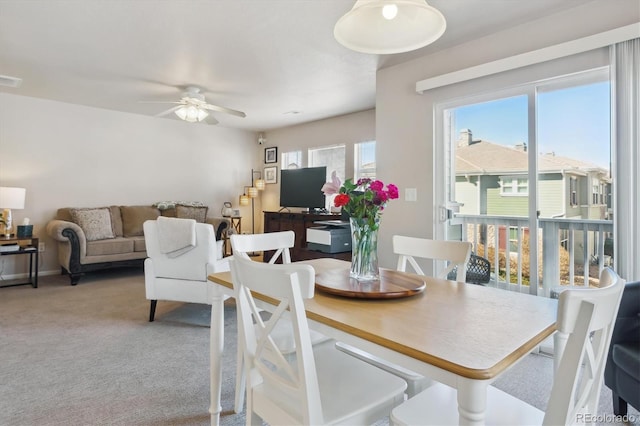 carpeted dining room with ceiling fan