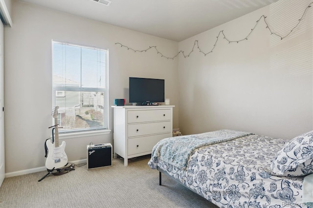 bedroom featuring light carpet and baseboards