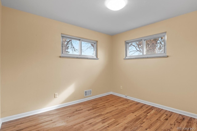 empty room with a wealth of natural light and light wood-type flooring