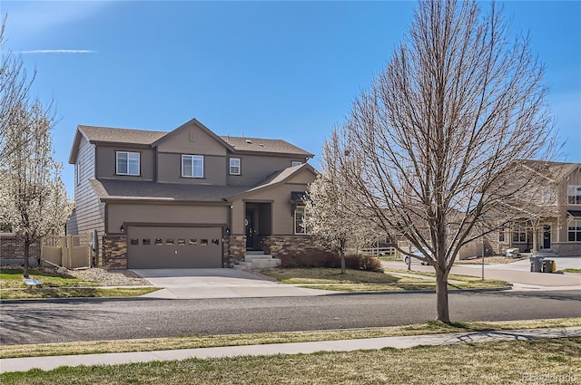 view of front of home with driveway, an attached garage, and stone siding