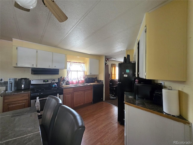 602 Vine St, Salida, CO 81201 - kitchen with black appliances, under cabinet range hood, dark wood-style floors, a sink, and a textured ceiling