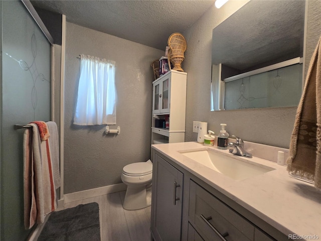 602 Vine St, Salida, CO 81201 - bathroom featuring vanity, a shower with shower door, toilet, a textured ceiling, and wood finished floors