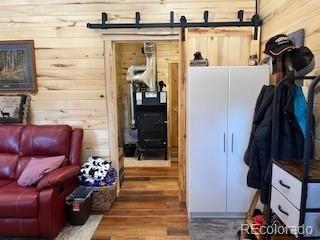 2945 Forbes Park Rd, Fort Garland, CO 81133 - interior space featuring a barn door, wood finished floors, and wooden walls