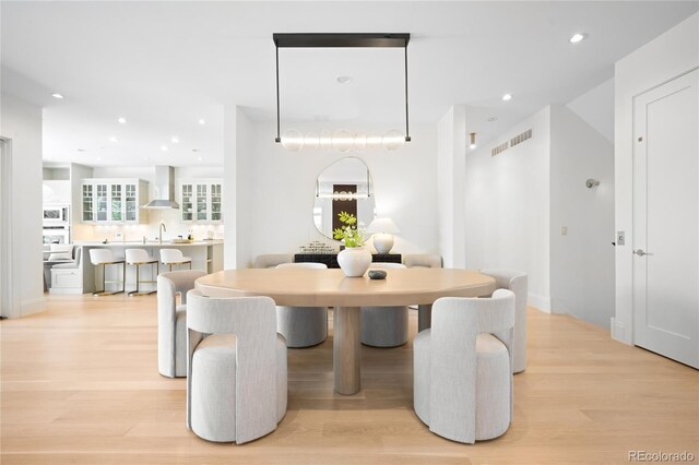 dining room with light wood-type flooring and recessed lighting
