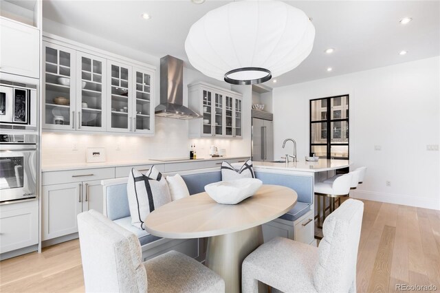 dining room with light wood-style floors, recessed lighting, and baseboards