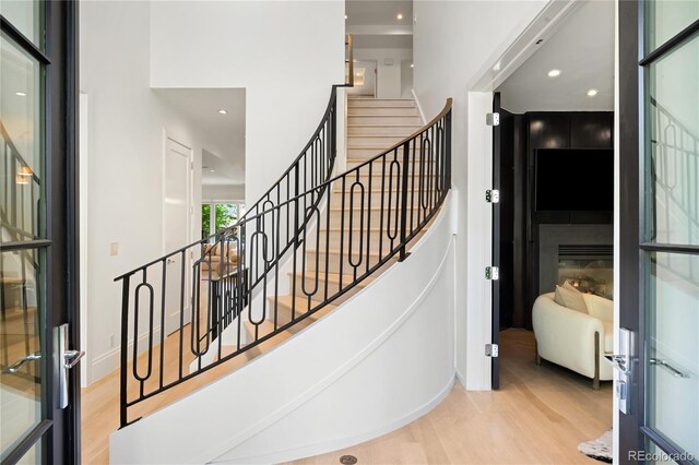 stairs featuring wood finished floors and recessed lighting